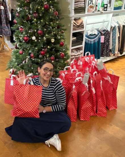 Maggie mit Glückstüten vor Weihnachtsbaum 2025